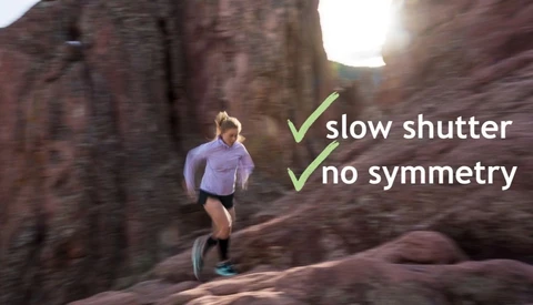 Woman trail running up red sandstone rock with motion blur, with overlaid text reading 'slow shutter' and 'no symmetry' beside checkmarks.