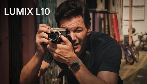 Photographer holding Lumix L10 camera in shooting position, looking through viewfinder