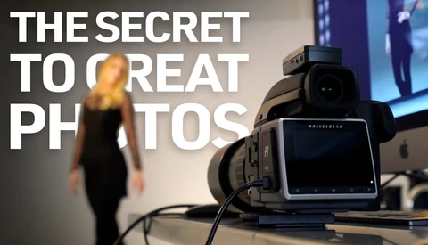 Hasselblad medium format camera on display with blurred figure and screen in background
