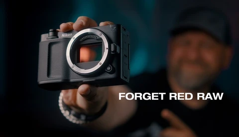 Photographer holding a Fujifilm mirrorless camera with sensor visible, text reads 'FORGET RED RAW'