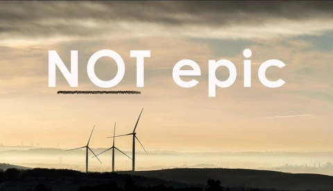 Three silhouetted wind turbines on a misty hill at sunset, with white text reading 'NOT epic' and a black scribble under 'NOT'