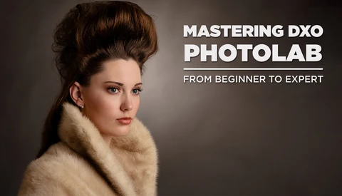 Portrait of a woman with styled hair and fur collar against neutral background.