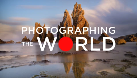 Graphic overlay reading 'Photographing the World' with a red circle replacing the 'O', displayed over a coastal landscape