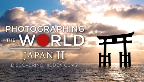 Traditional Japanese torii gate silhouetted against a dramatic sunset sky reflected in calm water.