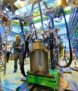 Photowalk attendee Andrew Hara stands beside the heart of an ISOLDE experiment - Photo by Ruben Lammerink