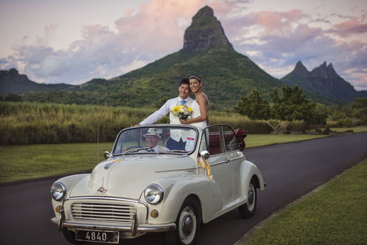 Couple in vintage car going to wedding with mountain and skies in the back