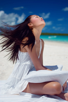 Girl waking up at the beach by the blue sky
