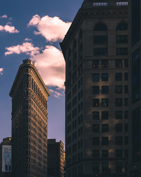 High contrast scene. Sunset in New York City. Photograph of the Flatiron building in New York. Street Photography. Travel Photography.