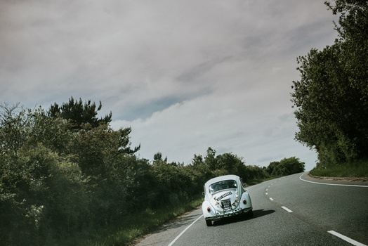 Benefits of working with a second shooter. A newly married couple driving in a car.