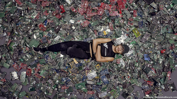 Image of Benjamin Von Wong posing on top of 4100 pounds of e-waste
