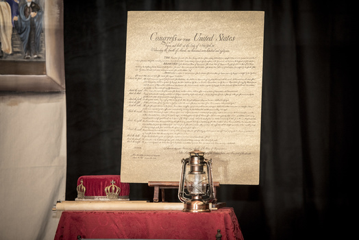 a photo of the US bill of rights next to a lantern on a table