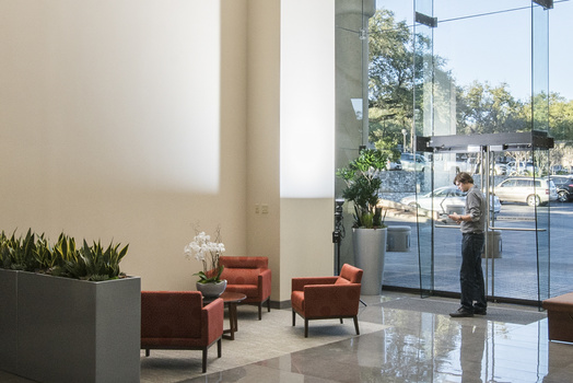 a photo of a photographer and a light on a stand in a commercial lobby