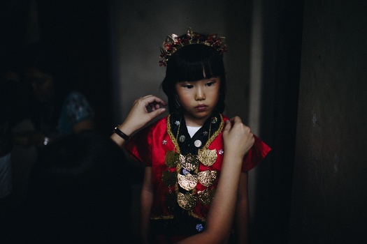 a small girl wearing a traditional Chinese dress