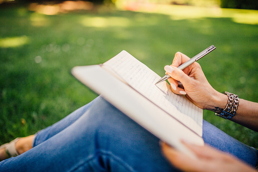 girl listing content ideas on notepad for photography blog