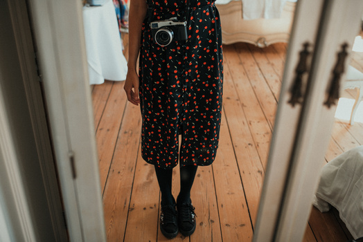 Get started in video making! Mirrorless camera hanging on a female photographer.