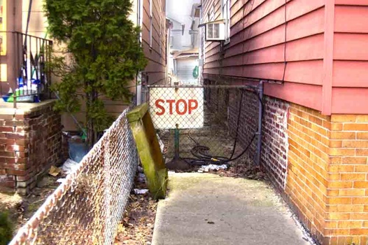 an HDR phot of a stop sign in an alley