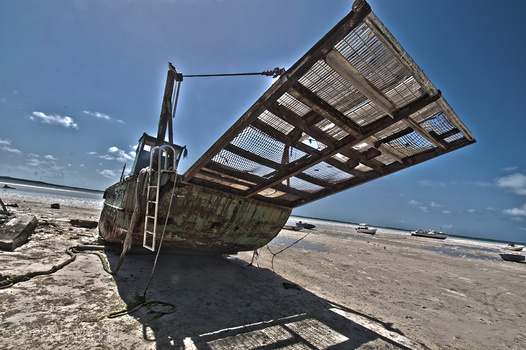 an overly-processed photo of a shipwreck on a beach