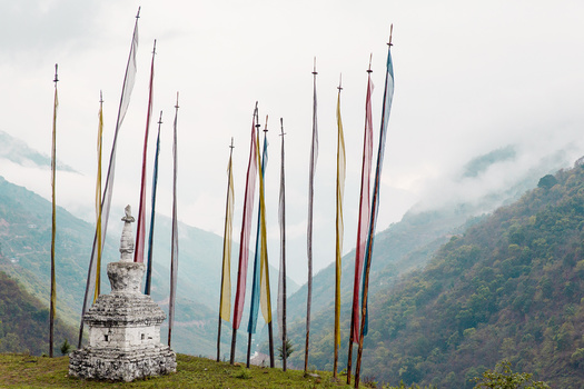 Flags and mist Prayer flags over a lush green valley