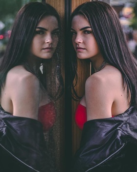 a woman posed in a storefront window reflection