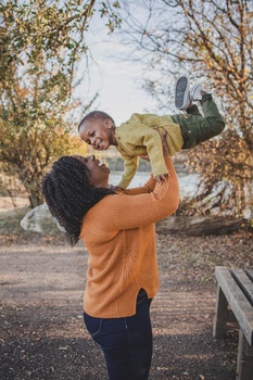 an image of a woman tossing her son in the air