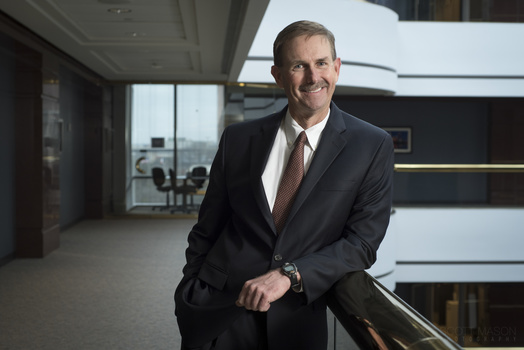 an executive portrait of a man in a suit, smiling