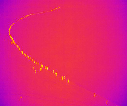 a thermal aerial photograph of rescuers walking down a path
