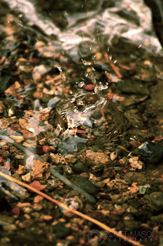 a water droplet splashing over rocks
