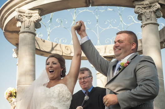 a couple at a wedding ceremony with their arms raised