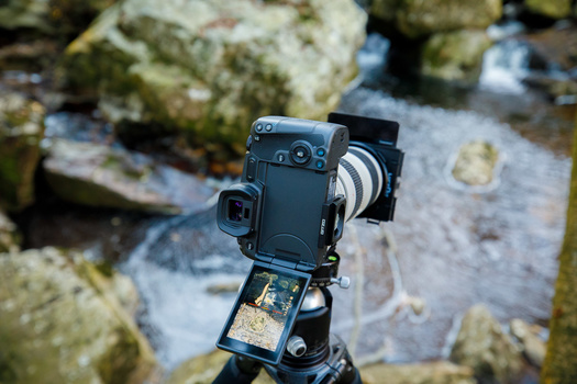 You cannot look through the viewfinder of a mirrorless camera without switching on the camera.