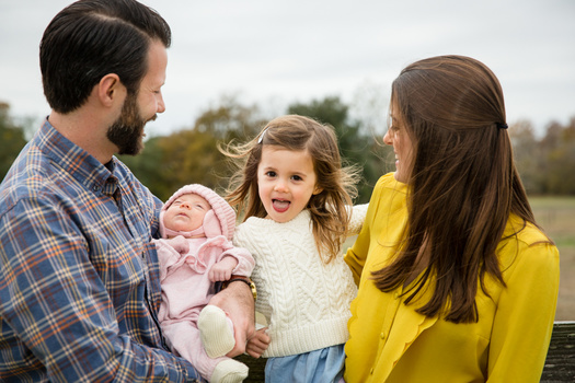 a family portrait with parents, a baby, and daughter