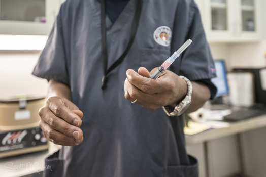 a healthcare working holding a syringe with a vaccine