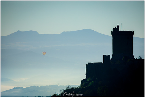 Reality or manipulation? I took this telelens photo from a hill in the French Auvergne region right after sunrise. The balloon drifted in the distance behind the castle. It is reality.