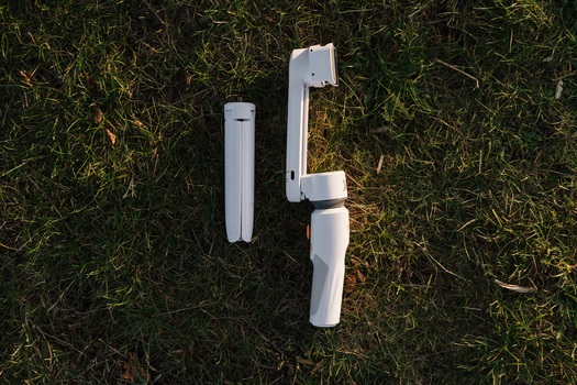 Zhiyun Smooth-XS gimbal size. Zhiyun Smooth-XS gimbal laid down on grass in a park.