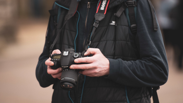 Man with DSLR in hands DSLR camera in hands