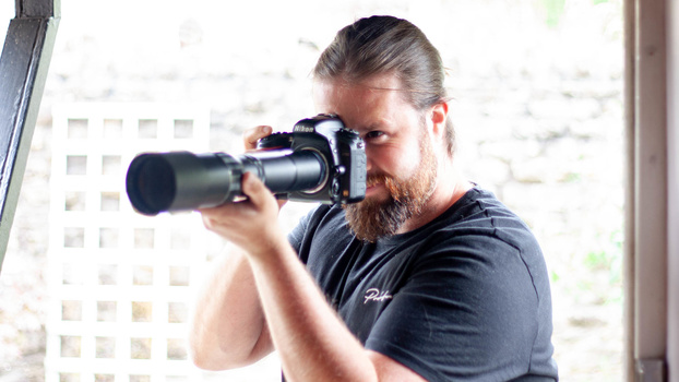 Man holding camera in doorway Man holding camera