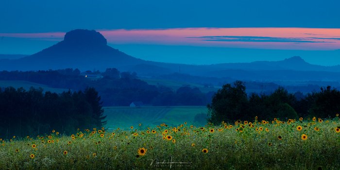 Don't limit yourself to one method. I have used weather elements, colors in post-processing, and a forground element to give a sense of depth.