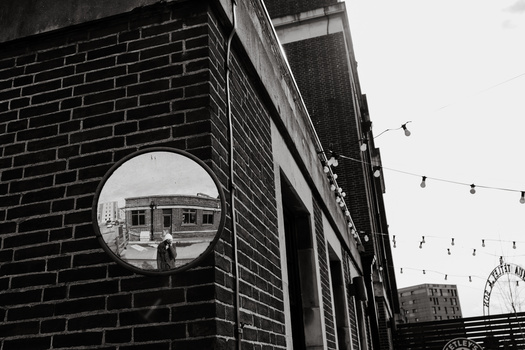 Creativity during a global pandemic. A person taking a self portrait in a mirror outdoors.