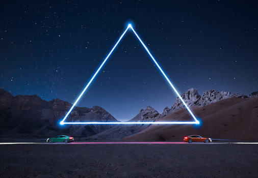 Neon blue triangle framing snow-capped mountains at night with two cars below.