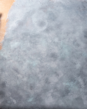 Close-up of concrete surface with weathered, mottled texture and subtle color variation.