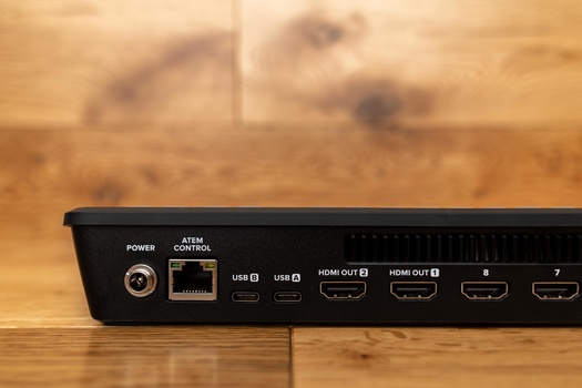 Close-up of a black video distribution device's rear panel showing power, network, USB, and multiple HDMI output ports.