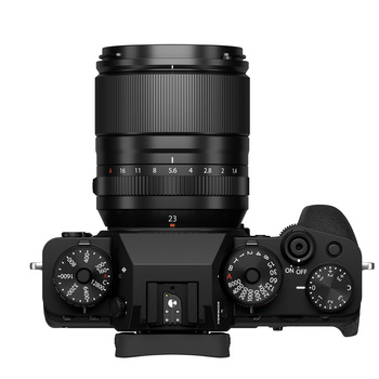 Top-down view of a black mirrorless camera with attached zoom lens and visible control dials.
