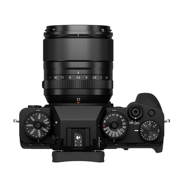 Top-down view of a black mirrorless camera with attached zoom lens and visible control dials.