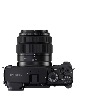 Top-down view of a mirrorless camera with attached standard zoom lens and visible control dials.