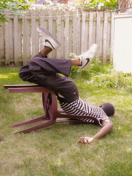 Person doing an inverted backbend on a wooden bench in a sunny backyard.