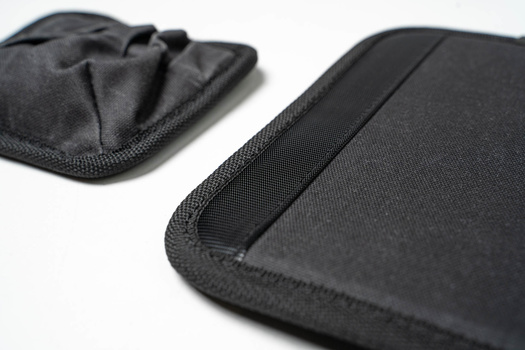 Close-up of two black neoprene protective cases with reinforced stitching and padded interiors.