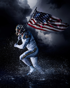 Athlete in motion holding an American flag against a dramatic stormy sky.