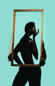 Silhouetted figure holding wooden frame against turquoise background.