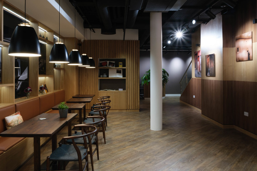 Modern interior space with wooden walls, pendant lighting, and structural column.