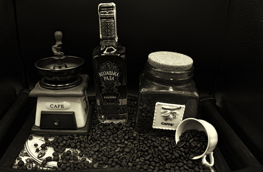 Styled flat lay of coffee-related items on dark background with coffee beans.