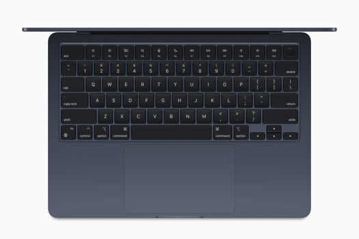 Top-down view of a laptop keyboard with dark gray keys and touchpad against a blue-gray chassis.